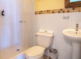 Un baño con inodoro, lavamanos y ducha.