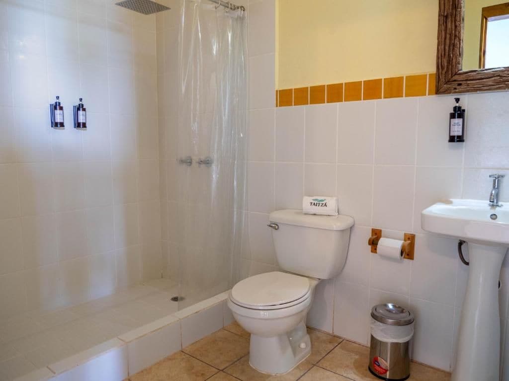A bathroom with a toilet, a shower, and a sink.