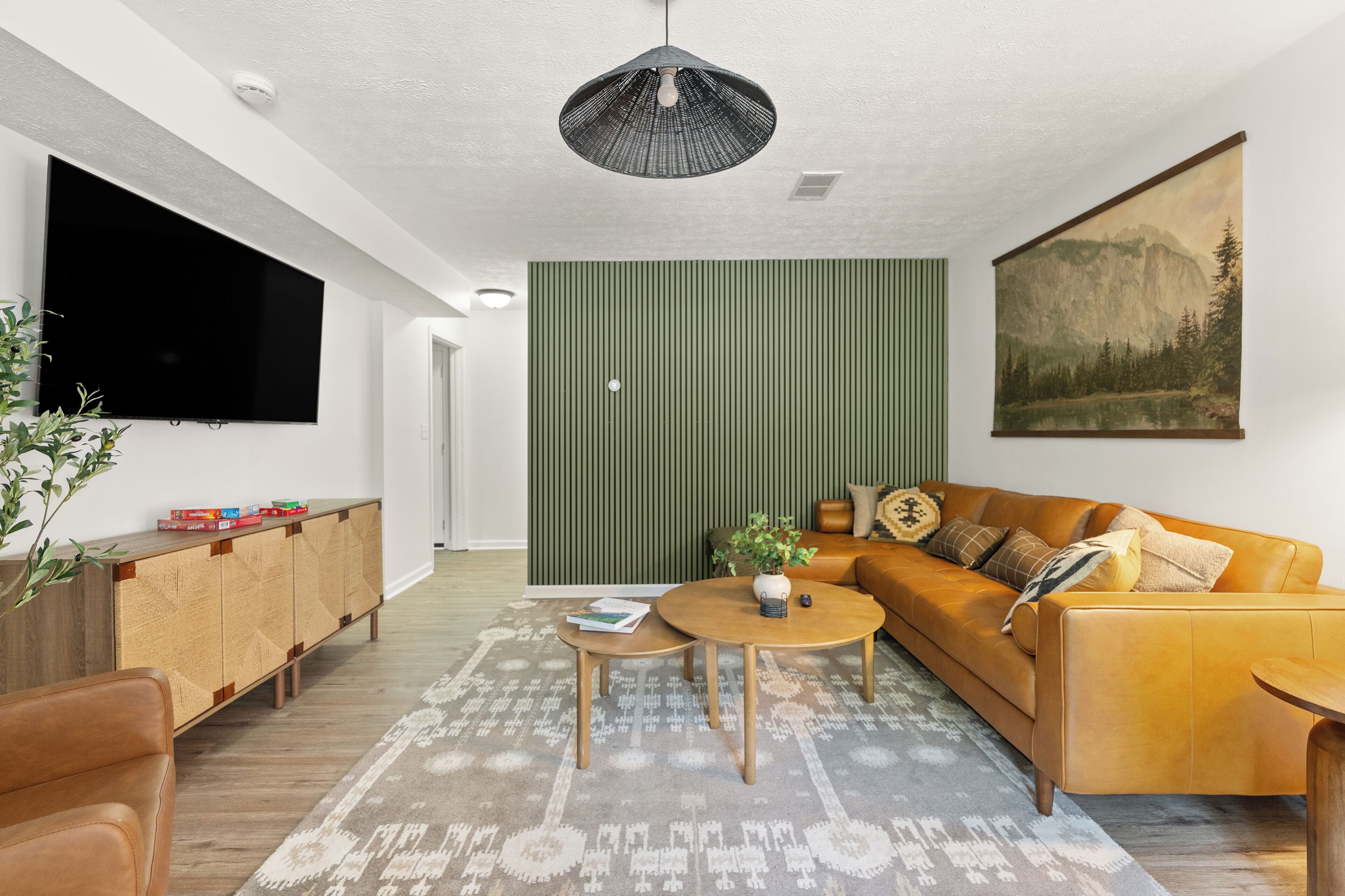 A modern living room with a sofa, coffee table, and a flat-screen TV.