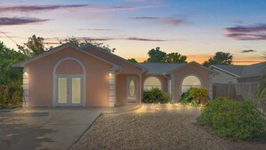 A two-story house with a driveway, a garage, and a well-maintained lawn. - Guava Ohana 17105-Beach Nearby-Sleeps 11 (Panama City Beach)