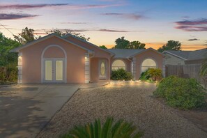 A two-story house with a driveway, a garage, and a well-maintained lawn. - Guava Ohana 17105-Beach Nearby-Sleeps 11 (Panama City Beach)