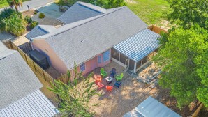 A residential area with multiple houses, a patio with outdoor furniture, and a clear sky. - Guava Ohana 17105-Beach Nearby-Sleeps 11 (Panama City Beach)