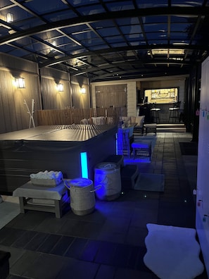 Een bar met krukken, een toog en een zithoek met tafels en stoelen.