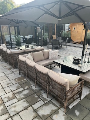 An outdoor seating area with wicker furniture and a covered section.