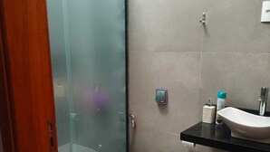A bathroom with a toilet, a sink, and a glass shower enclosure.