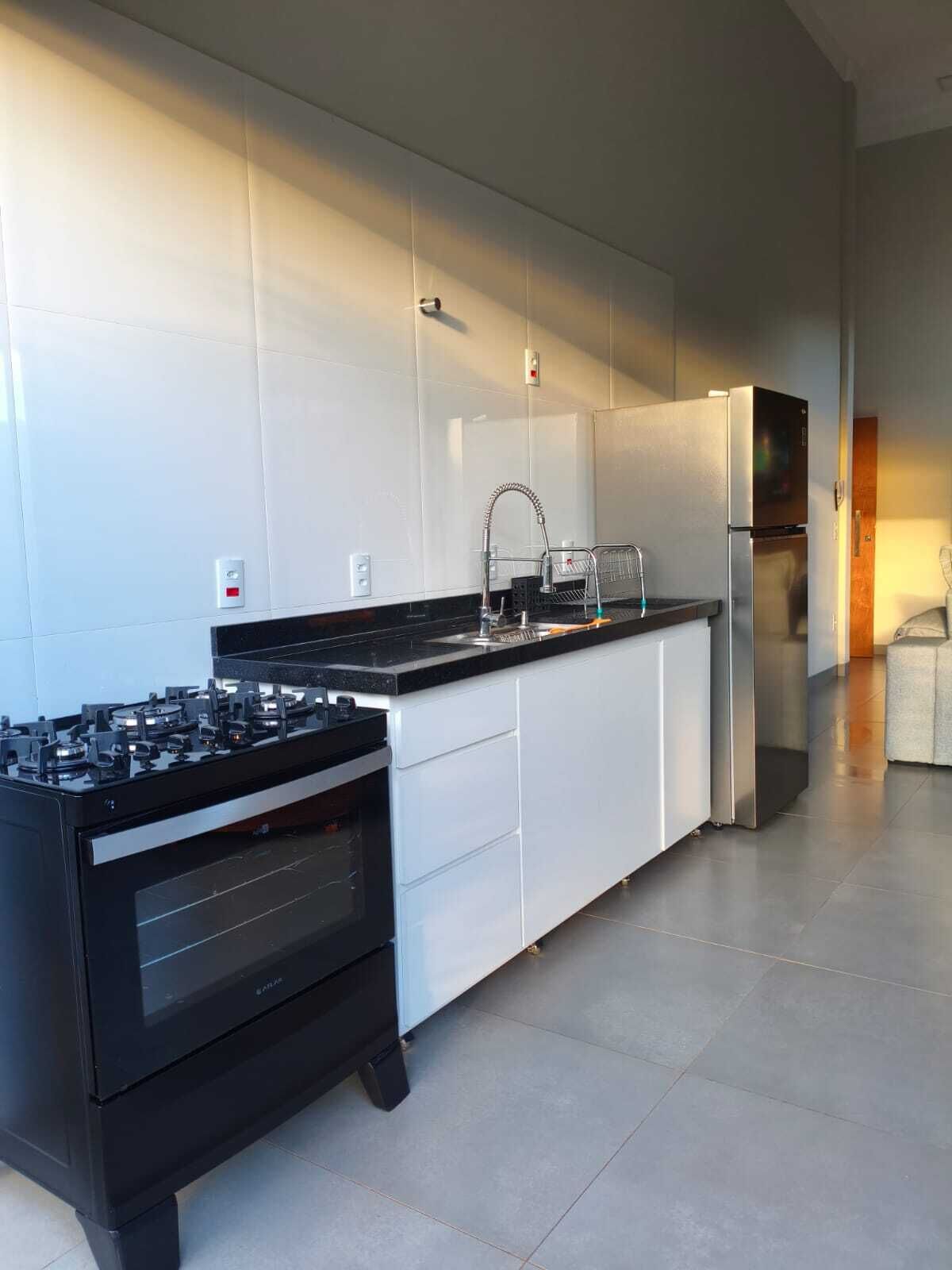 Una cocina moderna con estufa a gas, electrodomésticos de acero inoxidable y muebles de cocina blancos.