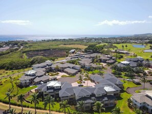 A residential area with houses, a golf course, and a body of water in the distance. - Spacious 3BR Garden-Level Villa with Central A/C & Lanai (Koloa)