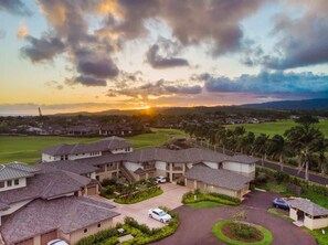 A residential area with houses, a golf course, and a sunset. - Spacious 3BR Garden-Level Villa with Central A/C & Lanai (Koloa)