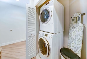 A laundry area with two stacked washing machines and a drying rack. - Spacious 3BR Garden-Level Villa with Central A/C & Lanai (Koloa)