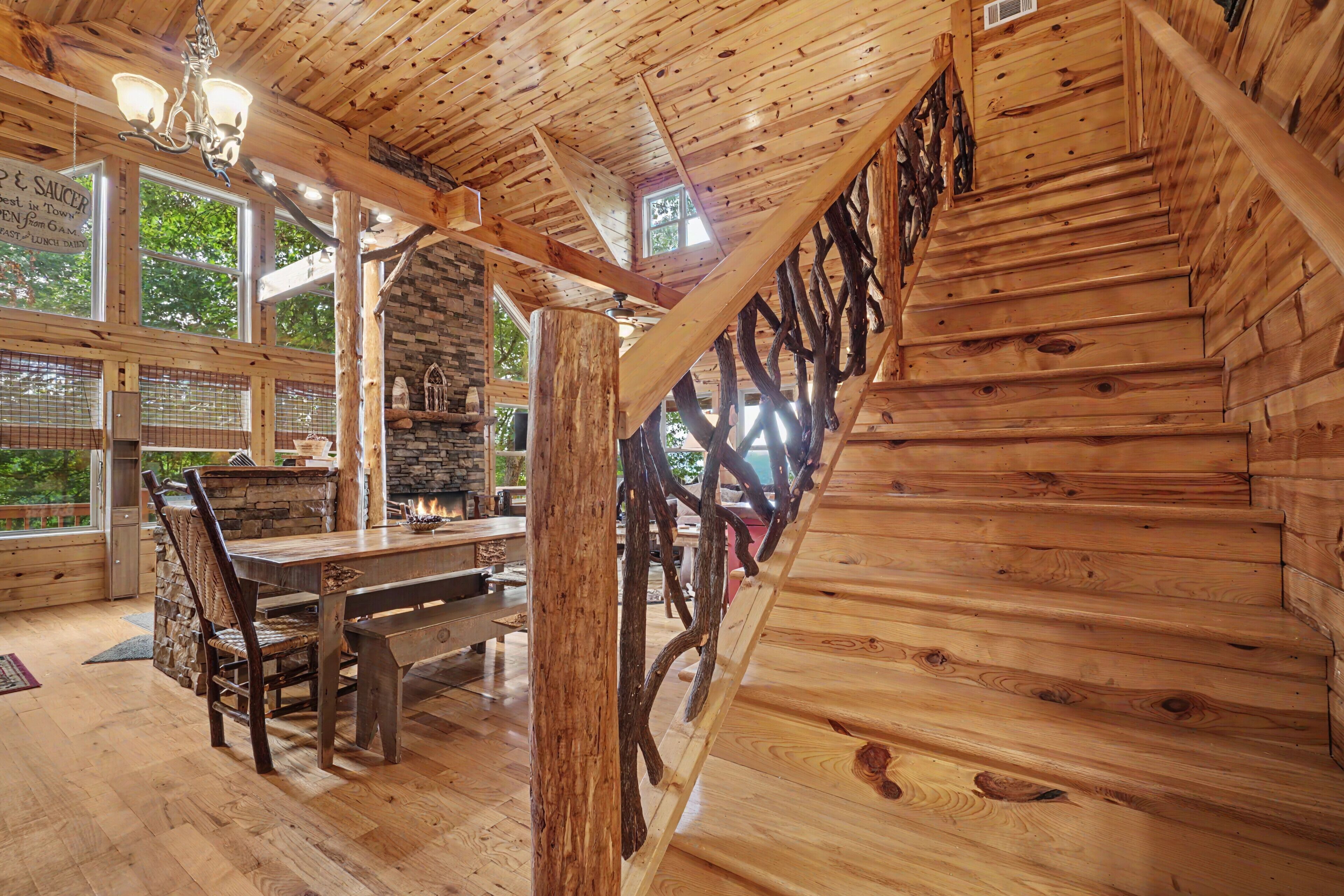 Un intérieur en bois comprenant un coin repas, une cheminée en pierre et de grandes fenêtres.