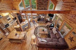 A cabin interior with a kitchen, dining area, and living room.