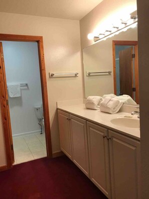 A bathroom with a vanity, a sink, a mirror, and a towel rack. - Barrier Island Station, Duck, NC - 2 Bedroom/Sleeps 8 (Duck)