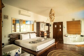 Una habitación de hotel con una cama grande, una bañera, un baño con lavamanos y un candelabro.