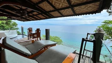 Un área de estar al aire libre cubierta con vista al mar.