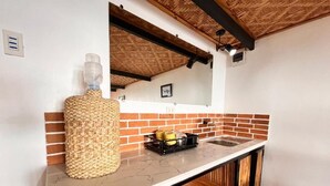 A kitchen with a marble countertop, a woven basket, and a sink.