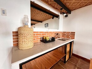 Una cocina con encimera de mármol, una cesta tejida y un lavamanos.
