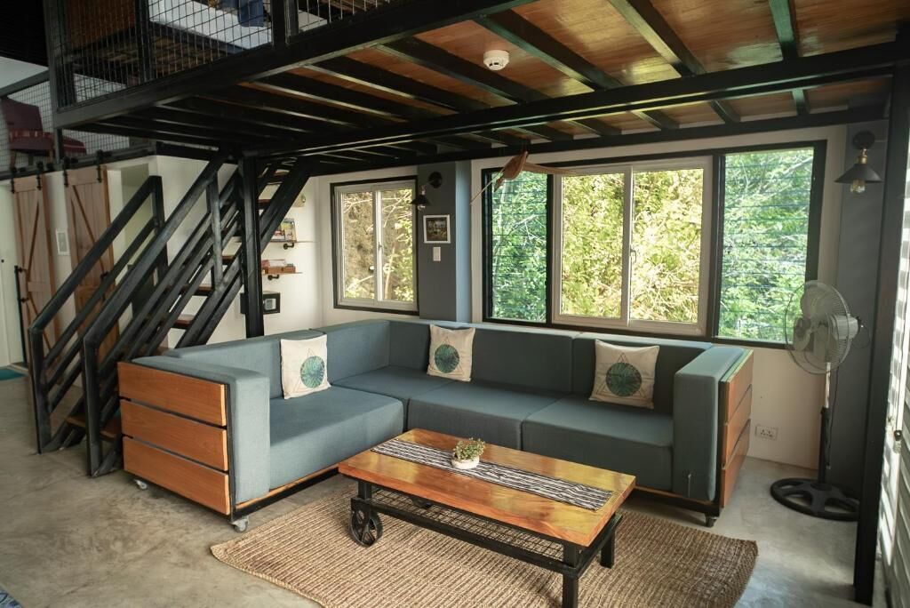Un salon avec un canapé d’angle, une table basse et un escalier.