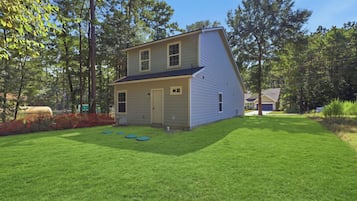 A two-story house with a front yard and a garage.