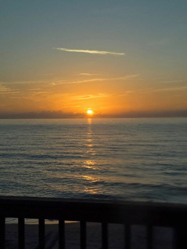 A sunset over a calm sea with a clear horizon.