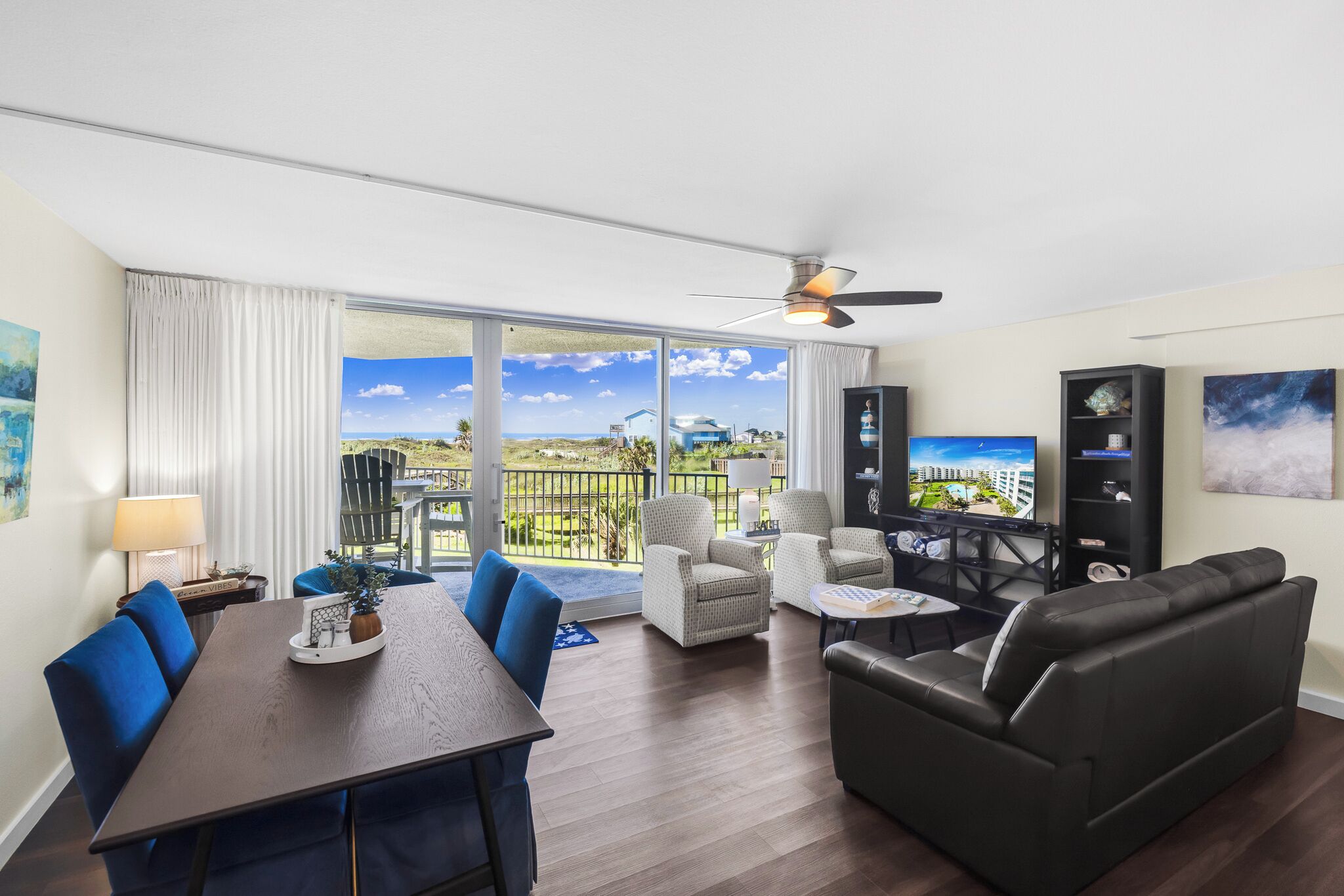 Een ruime woonkamer met een balkon, een eettafel en een bank.