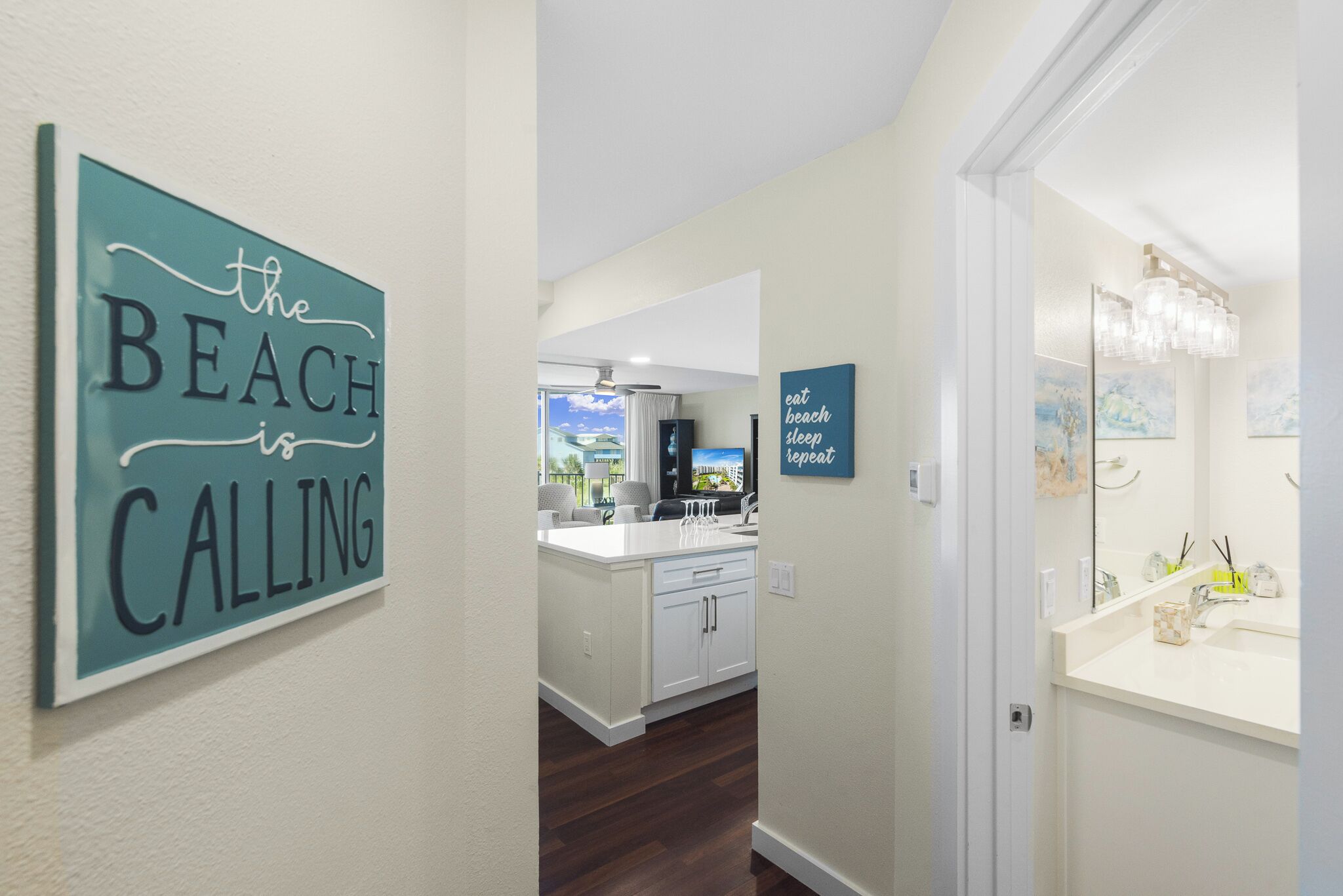 A hallway with a sign reading 'The Beach is Calling' and another sign stating 'eat, beach, sleep, repeat.'
