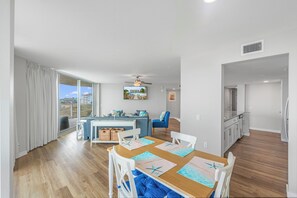 A modern apartment with a dining area, kitchen, and living space. - Sandcastle Condominiums 338 (Port Aransas)