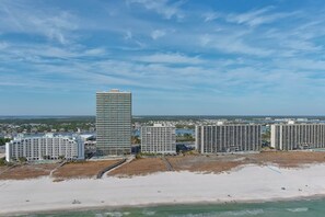 A coastal area with high-rise buildings, a sandy beach, and a clear sky. - Tidewater 101 - Three King Bedrooms on the Beach - Beachball Properties (Orange Beach)