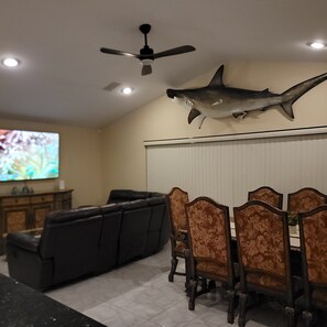 A dining area with a ceiling fan, a mounted shark decoration, and a television on the wall. - Waterfront 3 BR / 3 bath home w/ heated pool in Punta Gorda Isles. Sleeps 8. (Punta Gorda)