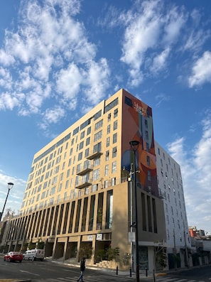 A multi-story hotel with a modern design, featuring a prominent entrance and a large sign. - New Studio · Rooftop · Historic Center of GDL (guadalajara)