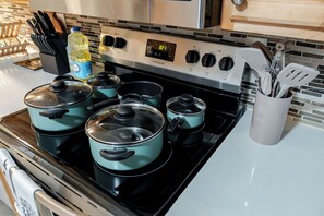 A kitchen with a stove, pots, a bottle of dish soap, and a utensil holder. - Entire Private Home w/ 4BR 3Bath, King Bed, Large Yard & Prime Area, Ranch Style (La Mesa)