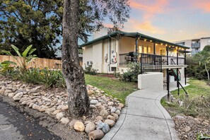A two-story house with a balcony, a stone pathway, and a wooden fence. - King Bed, Big Yard, Prime Area, Ranch, 4BR/3Bth (La Mesa)