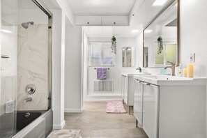 A modern bathroom with a glass-enclosed shower, a vanity with a mirror, and a towel rack. - King Bed, Big Yard, Prime Area, Ranch, 4BR/3Bth (La Mesa)