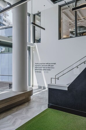 A modern interior with a quote on the wall, a staircase, and a view of the outside. - Raindance 2BR+2BA | Central DT | Pet-friendly (Kelowna)