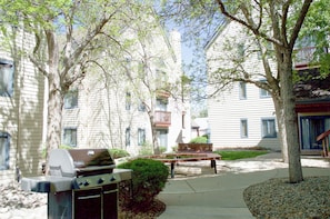 A residential area with a barbecue grill, a bench, and a tree. - The French Quarters -A Beautiful Boutique 2BR Retreat (Greenwood Village)
