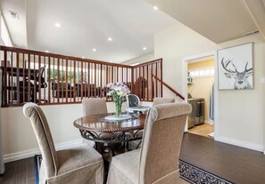 Un coin repas avec une table ronde, des chaises et un vase décoratif.