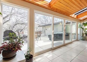 A sunlit room with large sliding glass doors leading to an outdoor patio area. - Old Broadmoor Retreat with 2 Universal Tesla Chargers - House 5 Bedrooms 9 Beds (Colorado Springs)