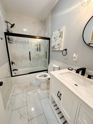 A modern bathroom with a glass-enclosed shower, a toilet, and a vanity with a sink. - Charming 1bedroom Suite 7minutes from Downtown Cleveland (Cleveland)