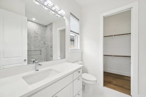Ein Badezimmer mit Waschbecken, Spiegel und Toilette.