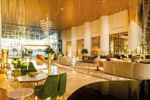 A spacious lobby with a high ceiling, large windows, and modern furnishings. - Cozy 1-bedroom condo with AC in amazing Cancun (cancun)