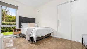Une chambre à coucher avec un lit, une table de chevet et une armoire.
