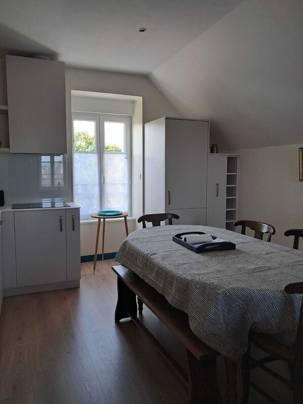 Una habitación pequeña con cama, escritorio, silla y ventana.