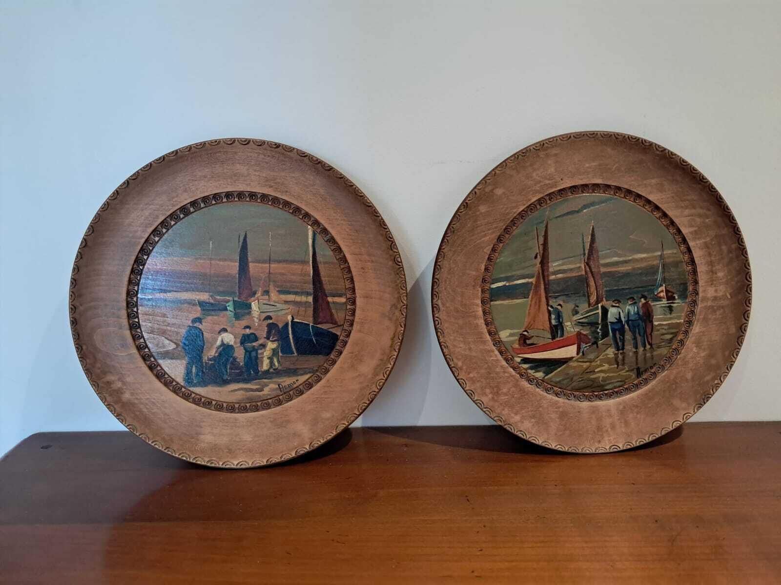 Two circular wooden frames with maritime scenes.