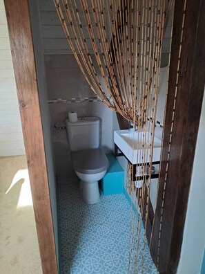 Un baño pequeño con inodoro, lavamanos y una decoración de bambú.