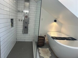 Ett modernt badrum med dusch, badkar och toalett.