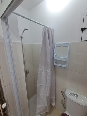 A bathroom with a shower, toilet, and a towel rack. - Vrbo Property (Tanger)