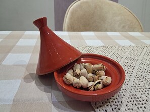 A red conical lid on a ceramic dish with nuts on a checkered tablecloth. - Vrbo Property (Tanger)