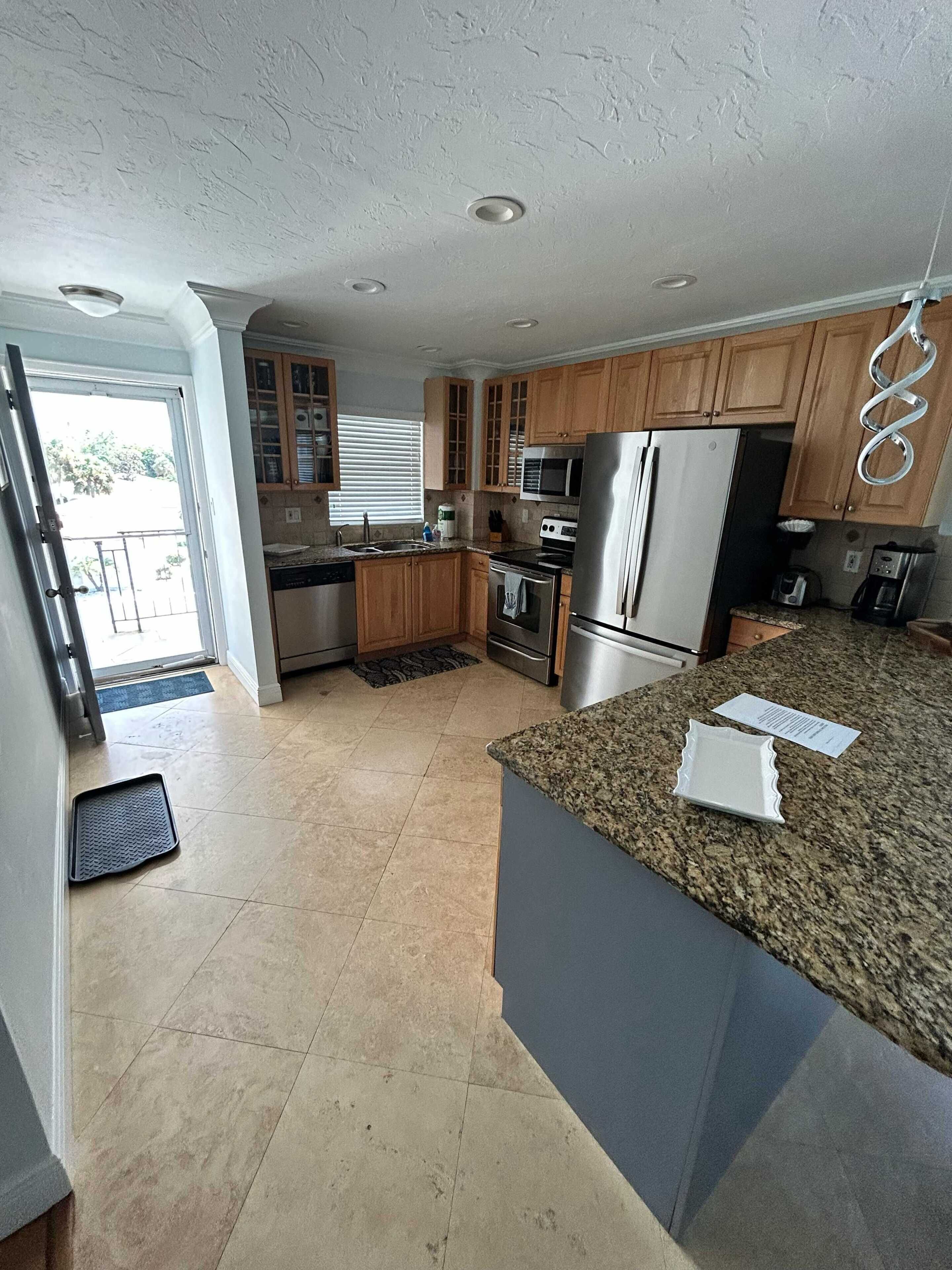 A modern kitchen with granite countertops, stainless steel appliances, and wooden cabinets.