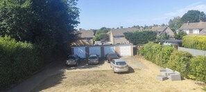 A residential area with a garage, parked cars, and a clear sky. - 2BR Frimley Home Near High Street (Camberley)