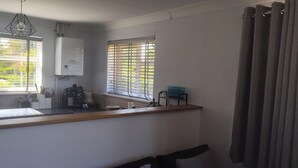 Eine Küche mit Einbauherd, Spüle und einem Fenster mit Jalousien.