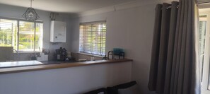 A kitchen with a built-in stove, a sink, and a window with blinds. - 2BR Frimley Home Near High Street (Camberley)